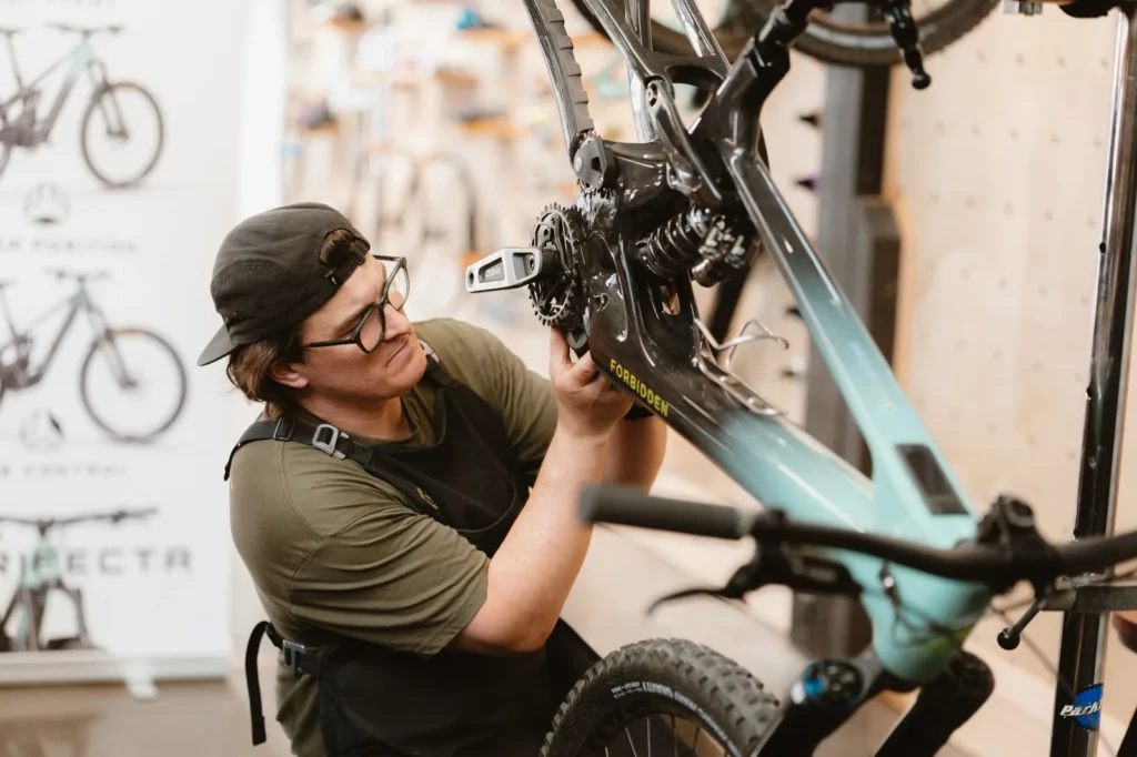 Close-up of an Outset mechanic servicing a Forbidden mountain bike drivetrain