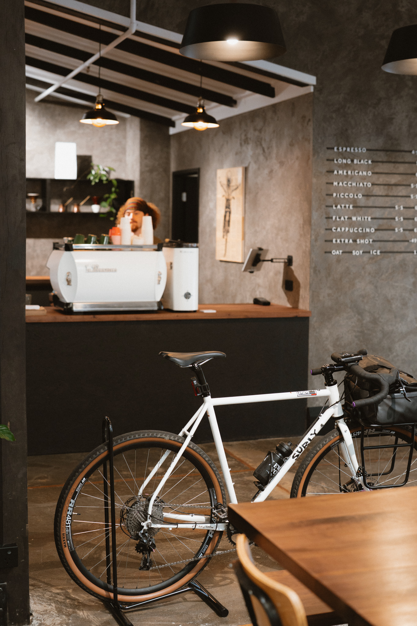 Espresso machine and a gravel bike beside the coffee counter inside Outset