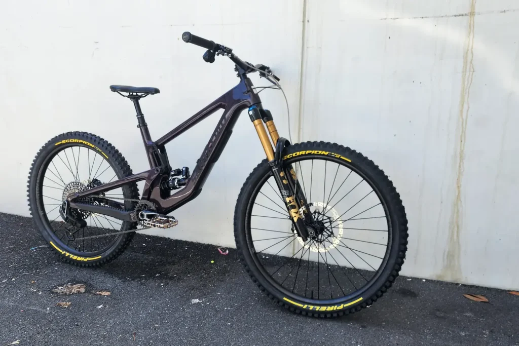 Dark full-suspension mountain bike with a gold fork, built by Outset